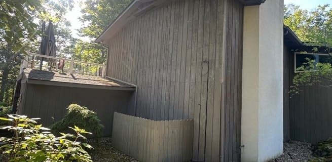 Gable end of vertical wood siding near the upper deck, before