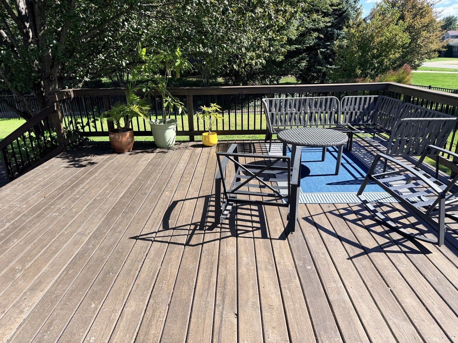 Freshly stained dark brown deck boards with patio furniture